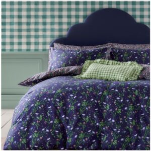 Cath Kidston Nightshade Navy bedset. Hand-painted flora, wispy leaves, and intricate sprigs dance amongst stars on this dreamy design. On a rich navy ground with vibrant greens, soft pinks and pale lilacs creating a magical, modern contrast. A dainty ditsy border on the pillows continues onto the bedding reverse. 180 thread count and 100% cotton cover.